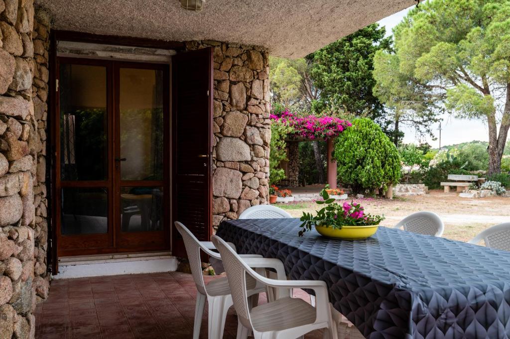 niebieski stół z krzesłami i żółtą miskę kwiatów w obiekcie Villa Bados 8 - Klodge w mieście Olbia