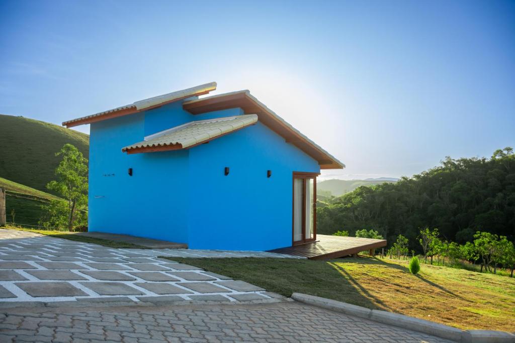 a blue house on top of a hill at Estalagem Meraki - Cunha SP in Cunha