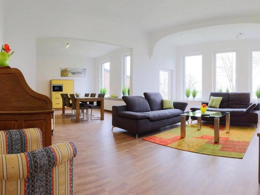 a living room with two couches and a table at Ferienwohnung Leuchtfeuer - Hof Sinswürden in Butjadingen