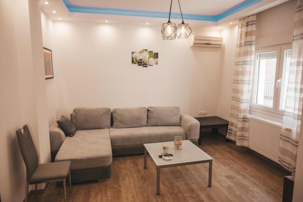 a living room with a couch and a table at Comfortable apartment in the city center in Katerini