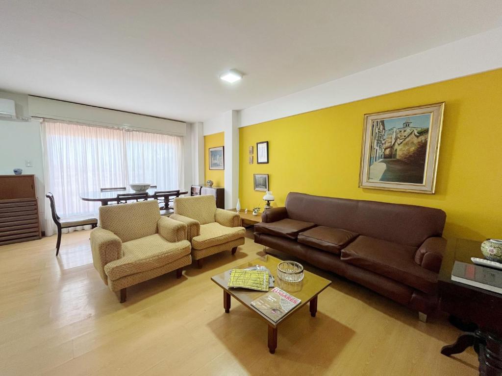 uma sala de estar com um sofá, cadeiras e uma mesa em Amplio Piso Vintage, Terraza con Vista a Sierras em Córdoba