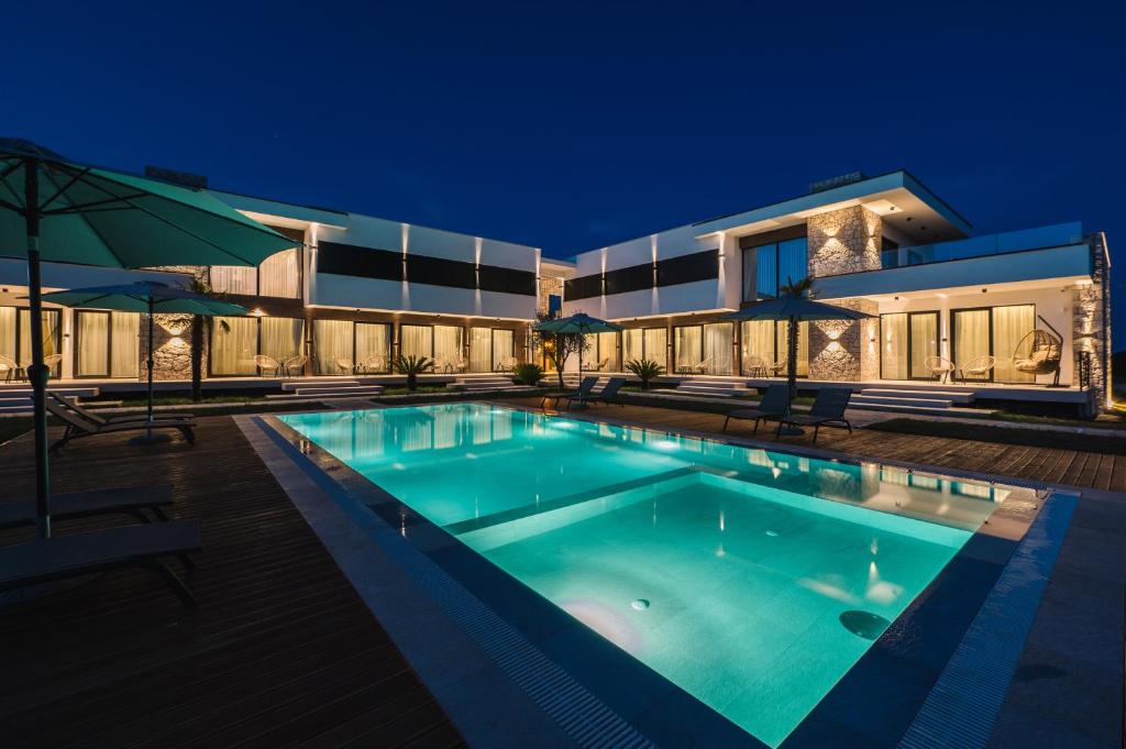 a swimming pool in front of a house at night at La Mandarine in Ulcinj