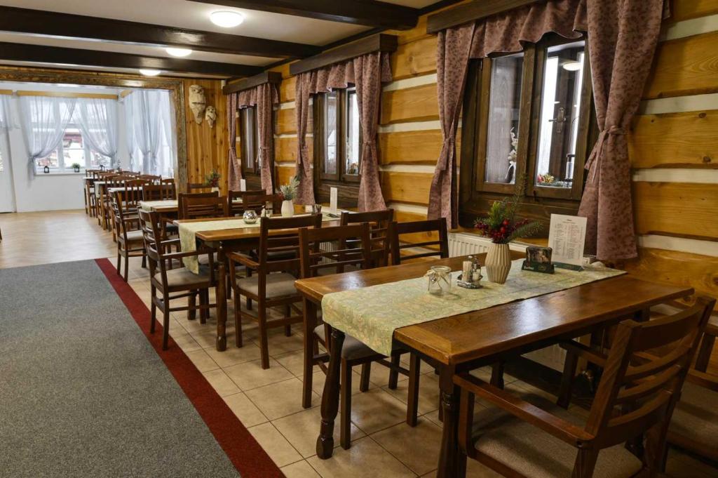 comedor con mesas y sillas de madera en Pension Na Vyhlídce, en Janov nad Nisou