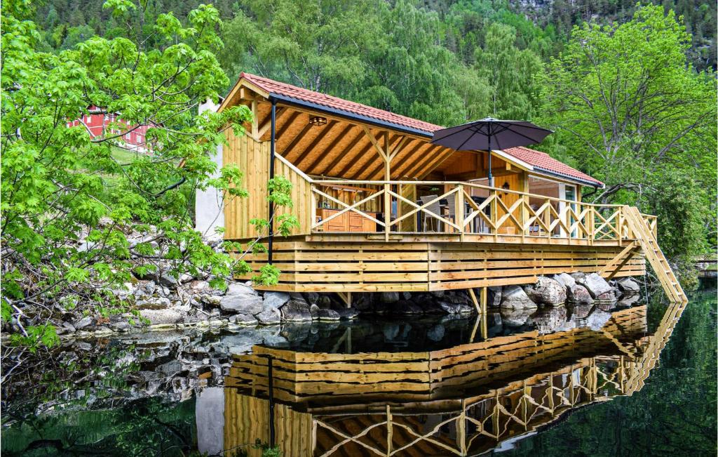 Vråliosen的住宿－Stunning Home In Vrliosen With Lake View，一座带雨伞的木屋