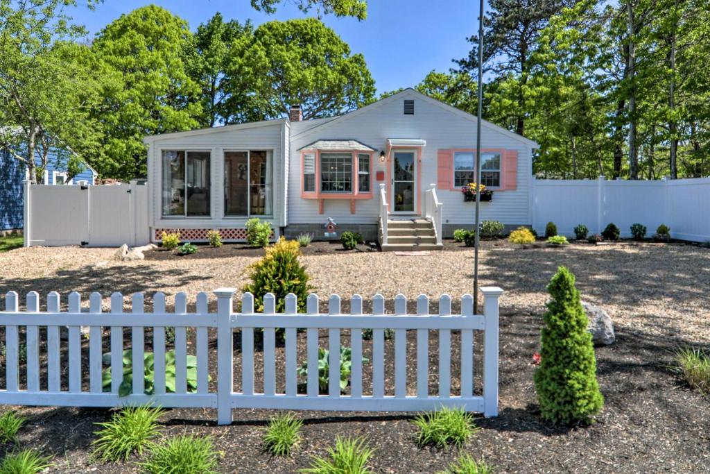 a small white house with a white fence at Adorable West Yarmouth Home about 2 Mi to Beach! in West Yarmouth