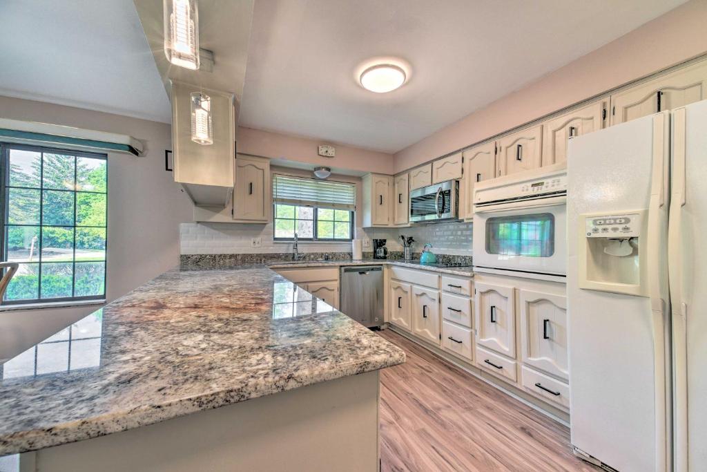 een grote keuken met witte apparatuur en granieten aanrechtbladen bij Cozy West Bloomfield Home - Fishing Nearby! in West Bloomfield