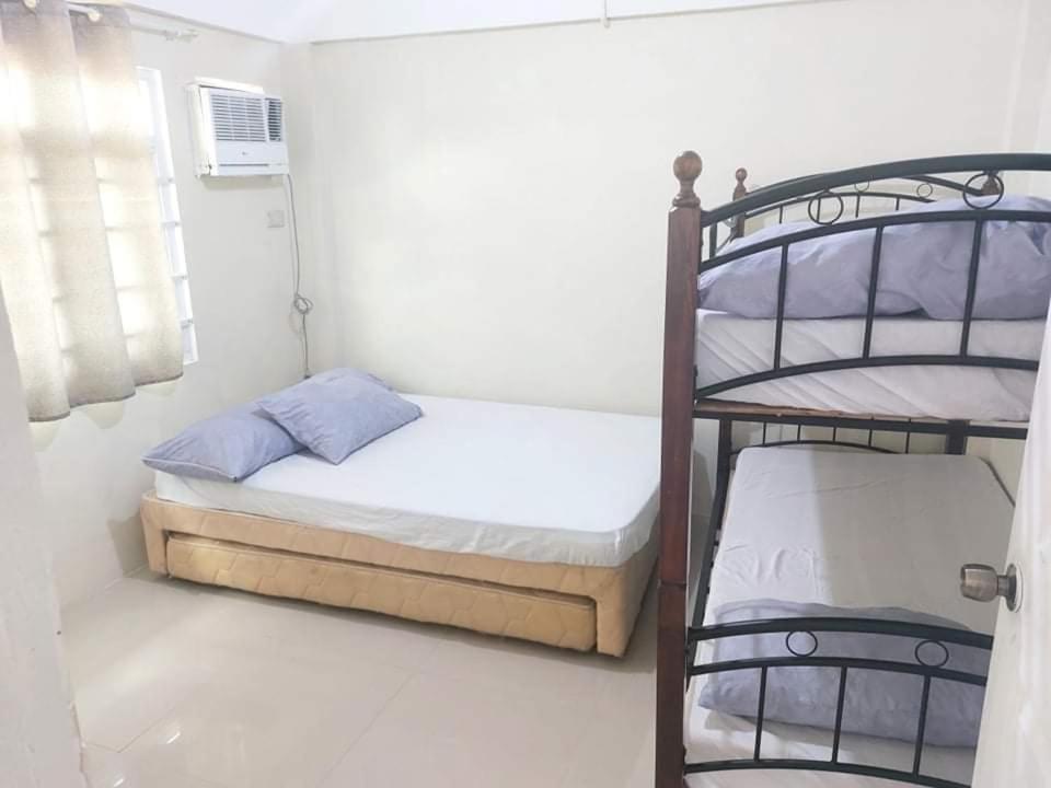 San Juan La Union Apartments في سان خوان: غرفة نوم صغيرة مع سريرين بطابقين وسرير بطابقين