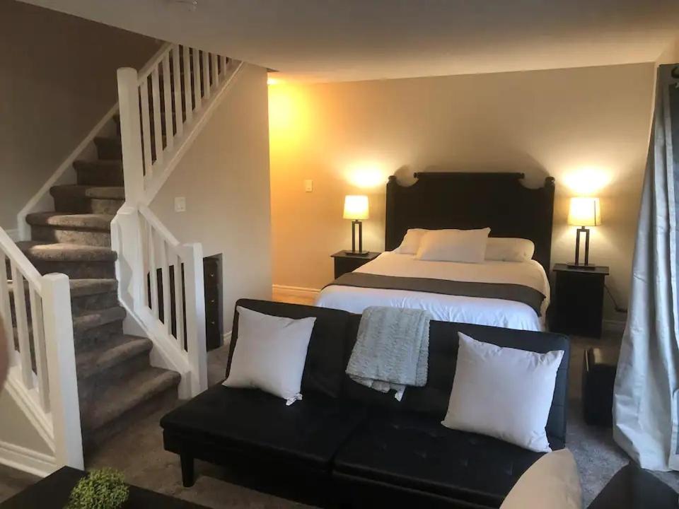 a bedroom with a bed and a couch and stairs at Freshly Upgraded Cozy Loft @ North Creek Resort in Blue Mountains