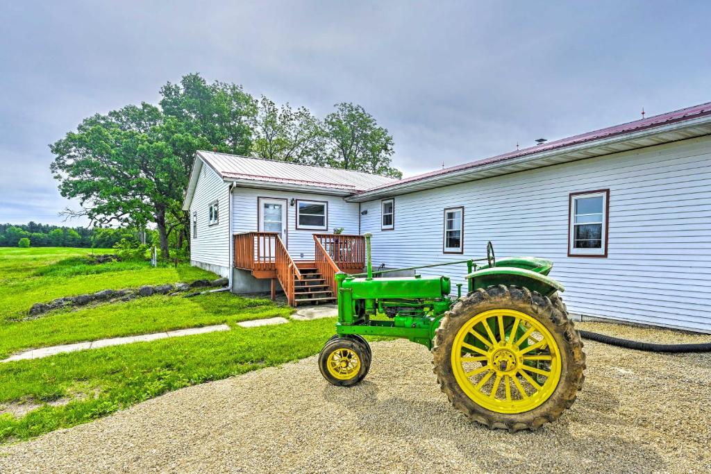 einem grünen Traktor vor einem Haus in der Unterkunft Stunning Wisconsin Retreat on Active Farm! in Spring Green