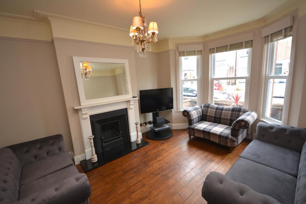 a living room with two couches and a fireplace at Luxurious Victorian Home by the sea - Myana House in Lowestoft