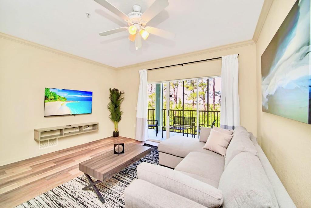 uma sala de estar com um sofá e uma televisão em Near Disney - Spacious 3BR Condo with Pool & Hot Tub! em Orlando