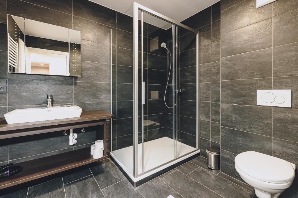 łazienka z prysznicem, toaletą i umywalką w obiekcie Alpine City Living by we rent, SUMMERCARD INCLUDED w mieście Zell am See