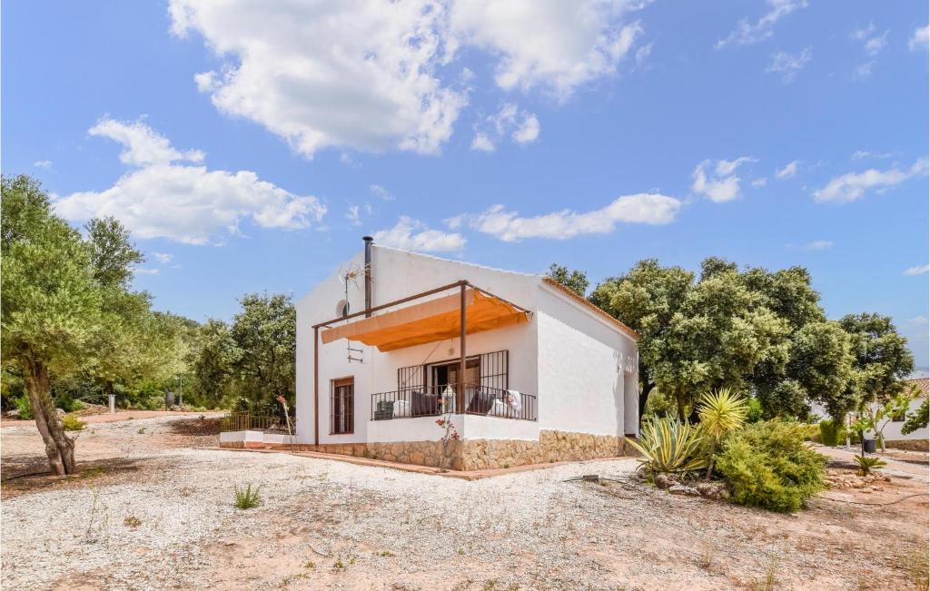 Cette petite maison blanche dispose d'un balcon dans un champ. dans l'établissement Awesome Home In Estepa With Wifi, à Estepa