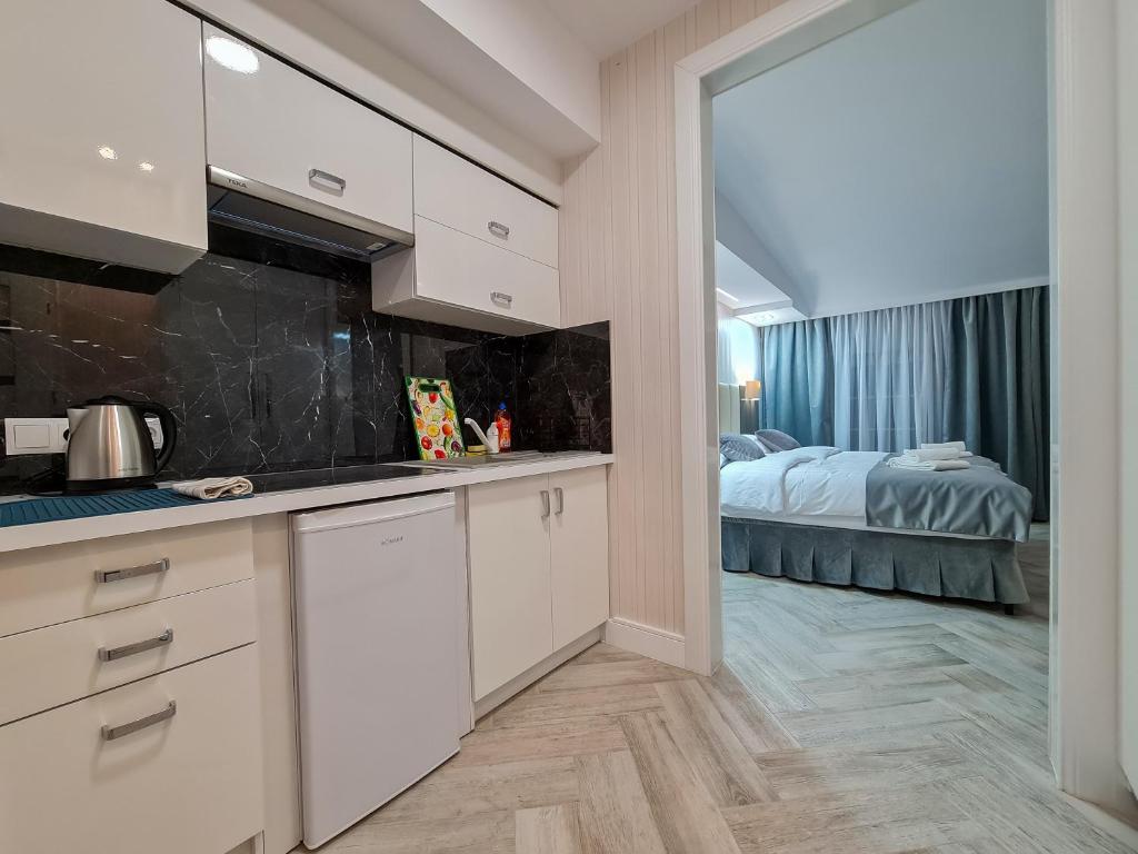 a kitchen with white cabinets and a bed in a room at Apartamenty Hayduk in Żary
