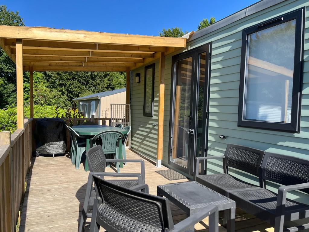 eine Terrasse mit Stühlen, einem Tisch und einer Terrasse in der Unterkunft Mobilhome tout confort R10 domaine de lanniron in Quimper