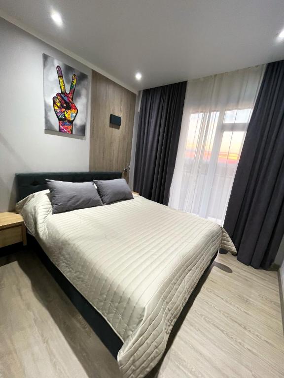 a bedroom with a large bed and a window at HERMES Cityview Apartment in Chişinău