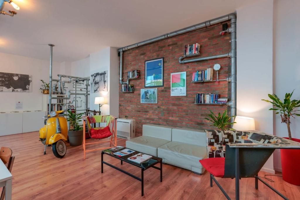 ein Wohnzimmer mit Sofa und Ziegelwand in der Unterkunft Funtanir Rooms in Bologna
