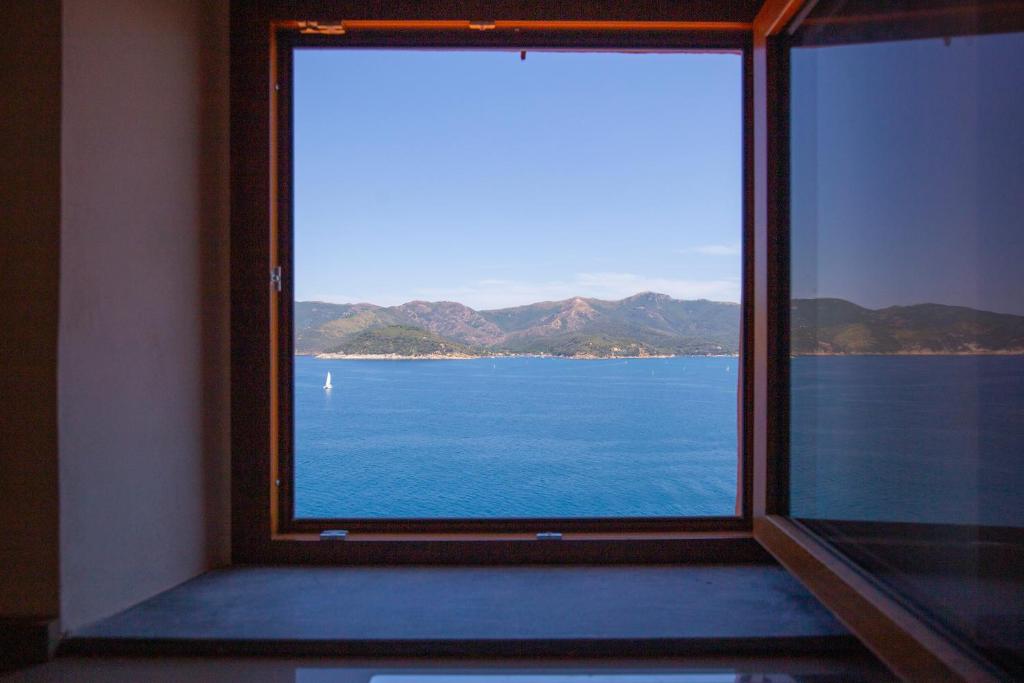 a window with a view of the water at HelloElba Appartamento Il Faro in Portoferraio