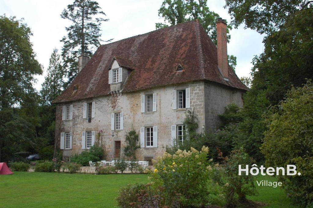 una antigua casa de piedra con techo en Le château du Fraysseix à Roziers-Saint-Georges en Roziers-Saint-Georges