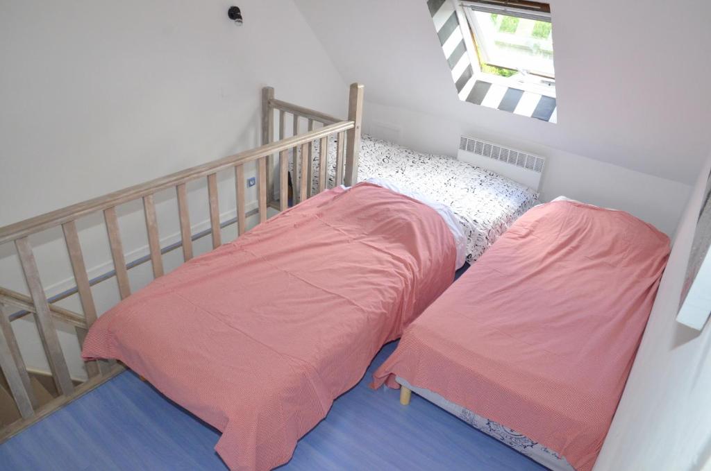 a bedroom with a crib with two pink sheets at le gite de Marie in Ferques