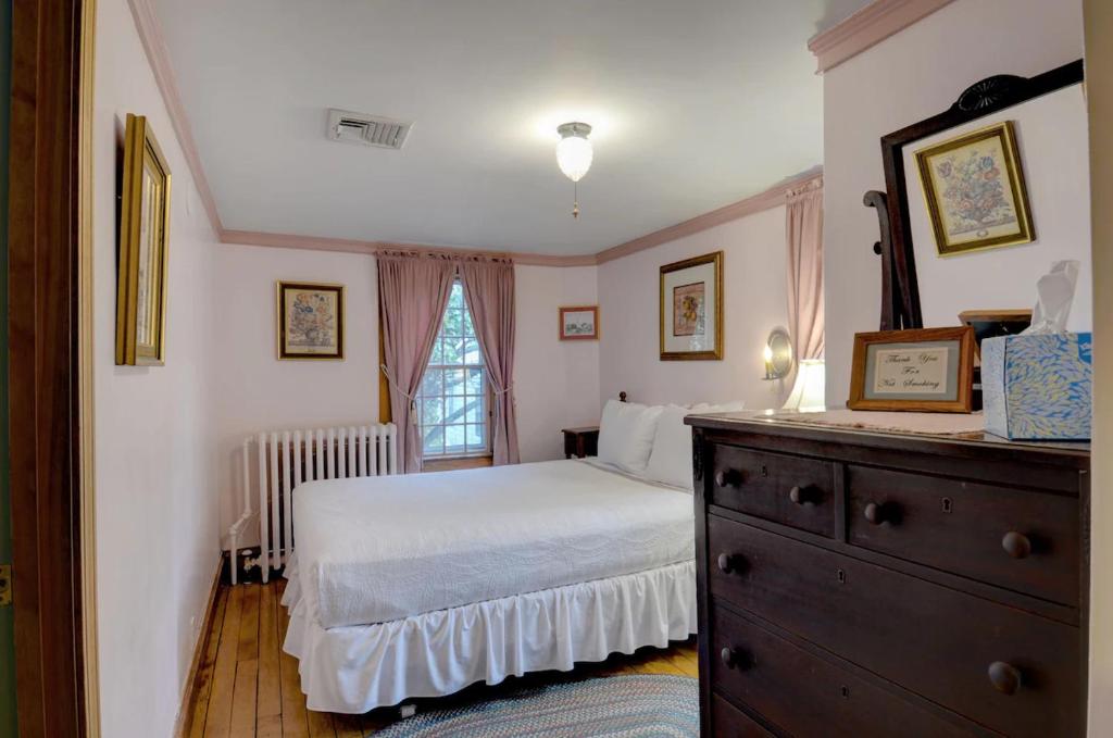 a bedroom with a bed and a dresser and a window at Melville House Newport in Newport