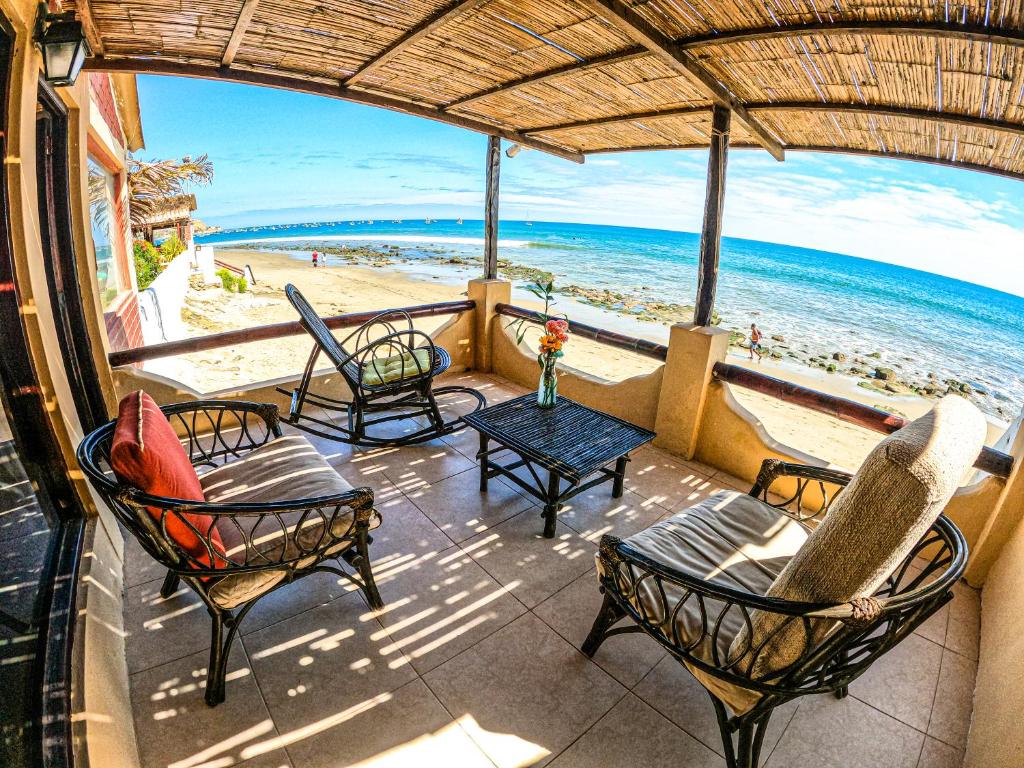 a patio with chairs and a table and the beach at Hotel Punta Ballenas in Máncora