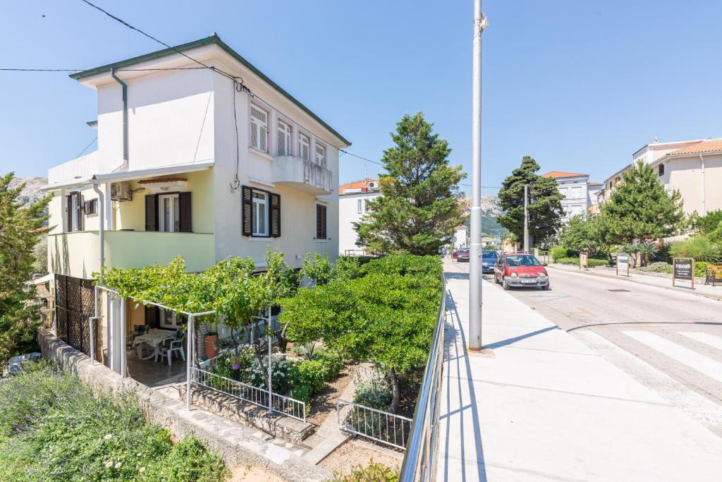 a house on a street with a balcony at Apartment Luiza with Terrace in Baška