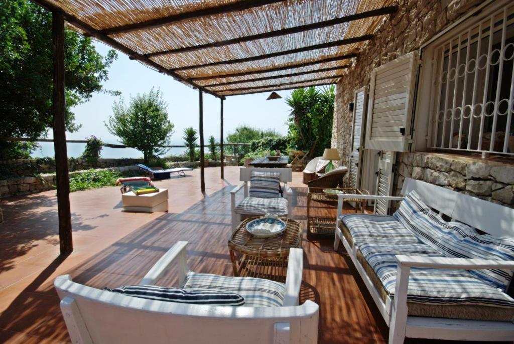 加利亞諾德爾卡波的住宿－TRULLO MEDITERRANEO - SANTA MARIA DI LEUCA，木制甲板上配有沙发和椅子的庭院