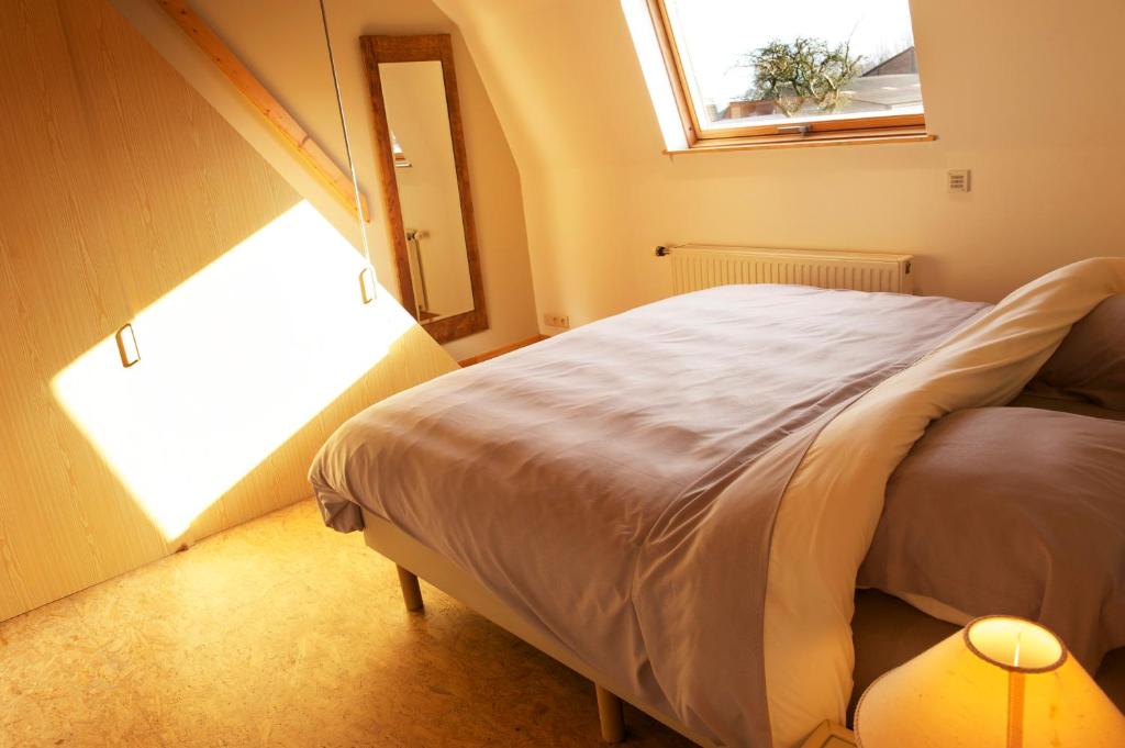 Au détour du Trieu في Estaimbourg: غرفة نوم صغيرة بها سرير ونافذة