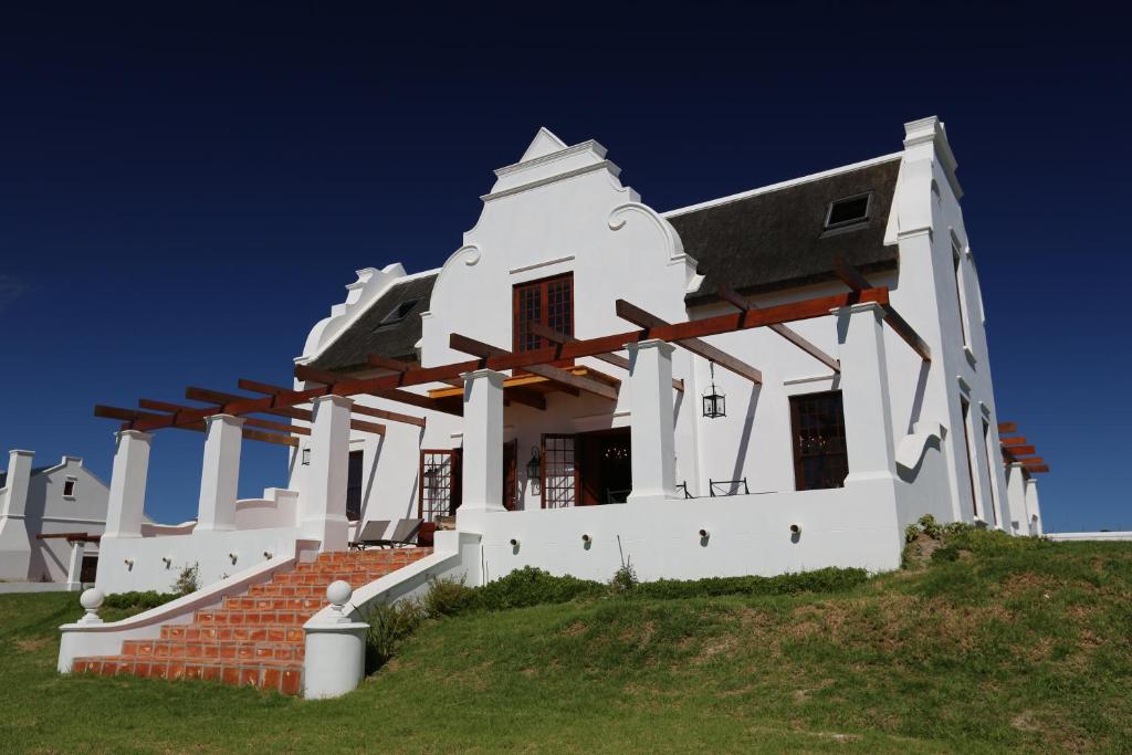 a white house on top of a hill at Doornbosch Estate in Elim