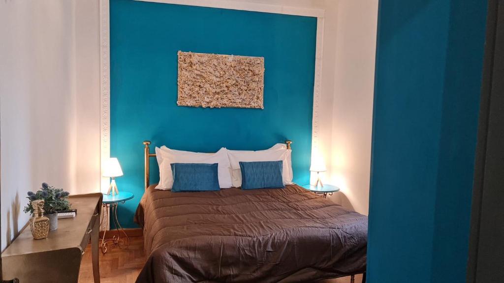 a bedroom with a blue wall and a bed with pillows at Civico 71 in Florence