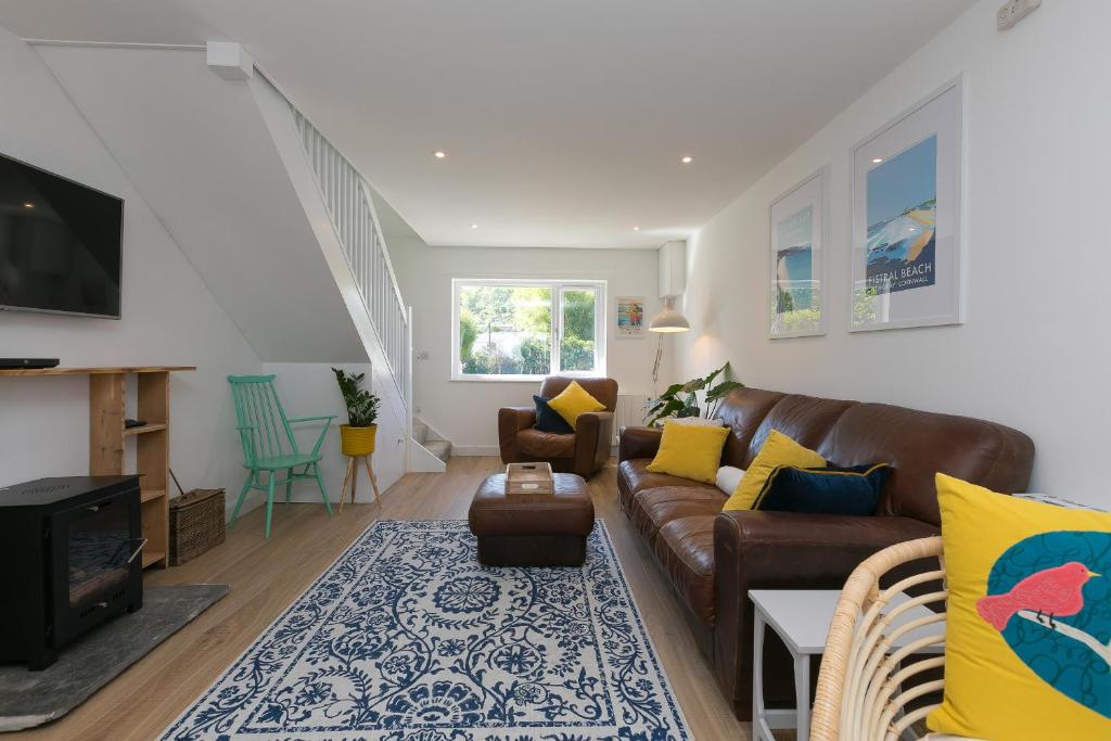 a living room with a brown couch and a tv at Hillywych Studio in Redruth