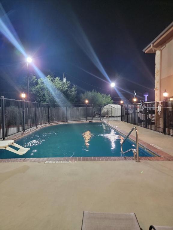 una piscina vuota di notte con luci di Karnes City Lodge a Karnes City