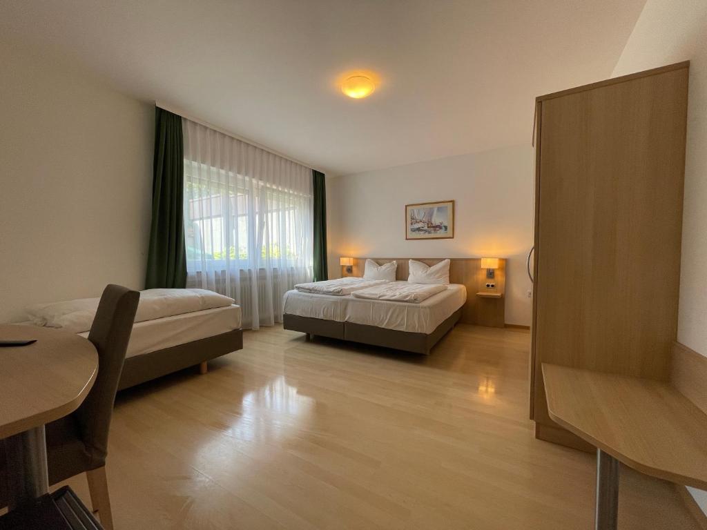 ein Hotelzimmer mit 2 Betten und einem Tisch in der Unterkunft Hafner Hotel- Apartment in Stuttgart