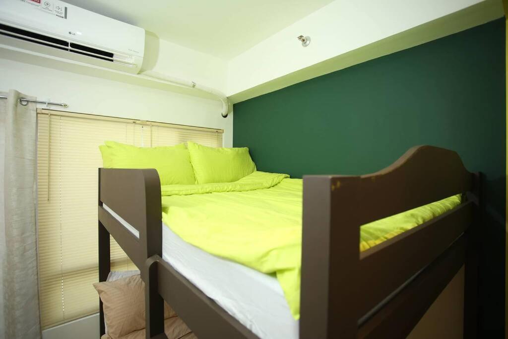 a bunk bed in a room with a green wall at A2J Luxury 1BR Tagaytay Suite Near Skyranch, Malls in Tagaytay