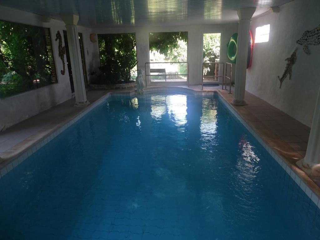 a swimming pool with blue water in a house at les Quatre Vents in Bragny-sur-Saône