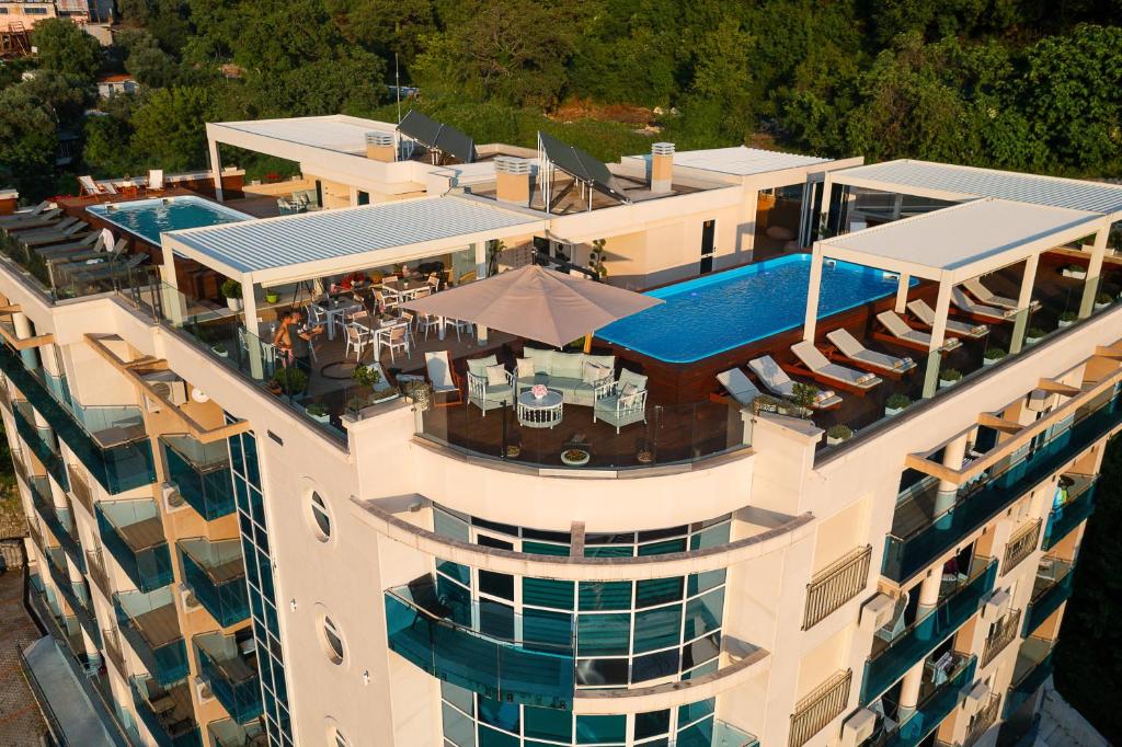 an aerial view of a building with a swimming pool at Vujanović Apartments in Sveti Stefan
