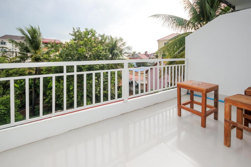 a balcony with white railing and a wooden table at Blossoming Romduol Boutique in Siem Reap