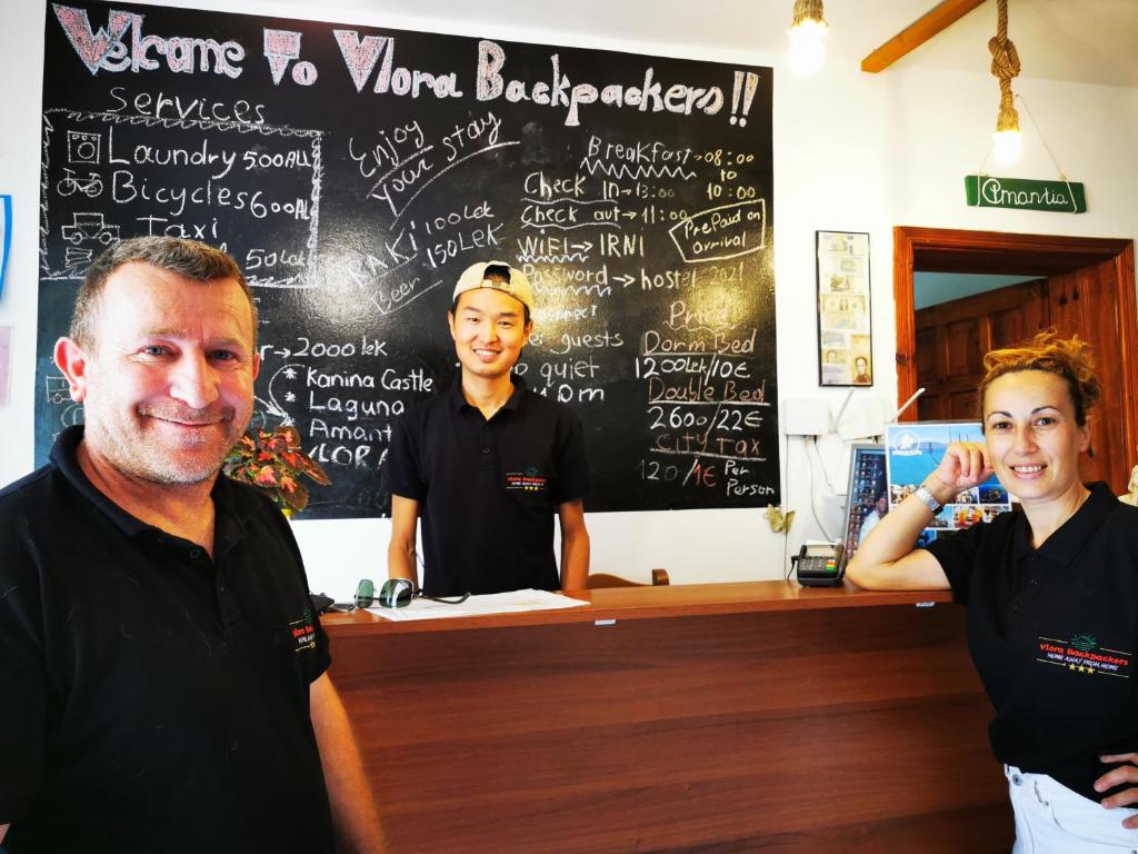 a man and two women standing in front of a counter at Vlora Backpackers Hostel & Bar in Vlorë