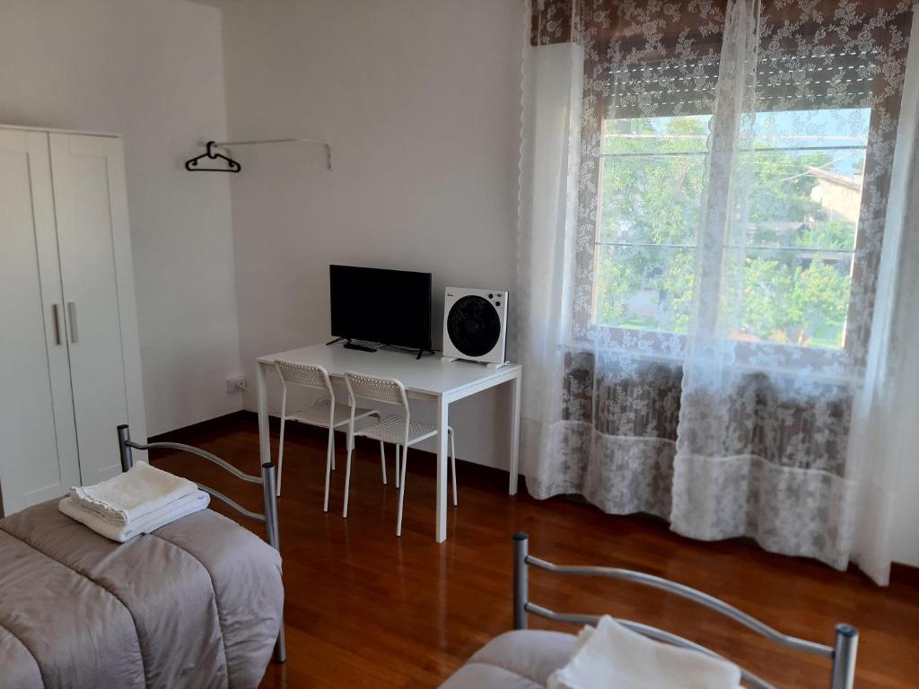 a living room with a desk with a television and a window at EasyRoom Piovene Rocchette in Piovene Rocchette