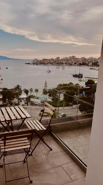a balcony with chairs and a view of the water at Kanes Bohemian Boutique Hotel in Sarandë