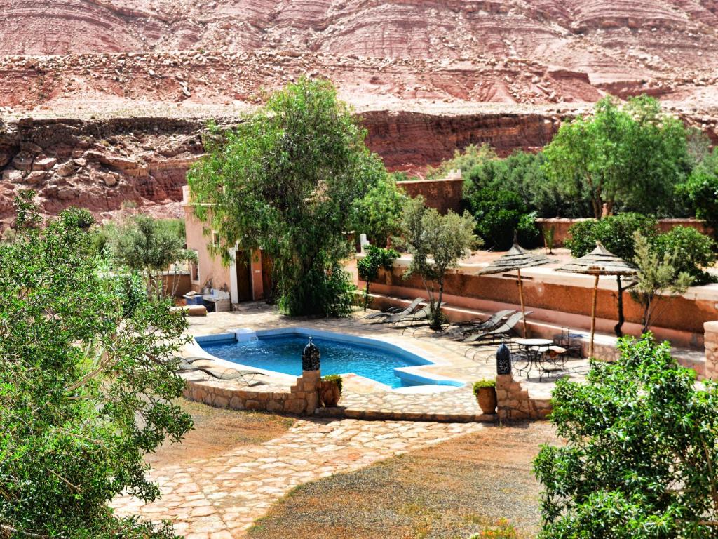 a swimming pool with a mountain in the background at Guest House Defat Kasbah in Aït Benhaddou
