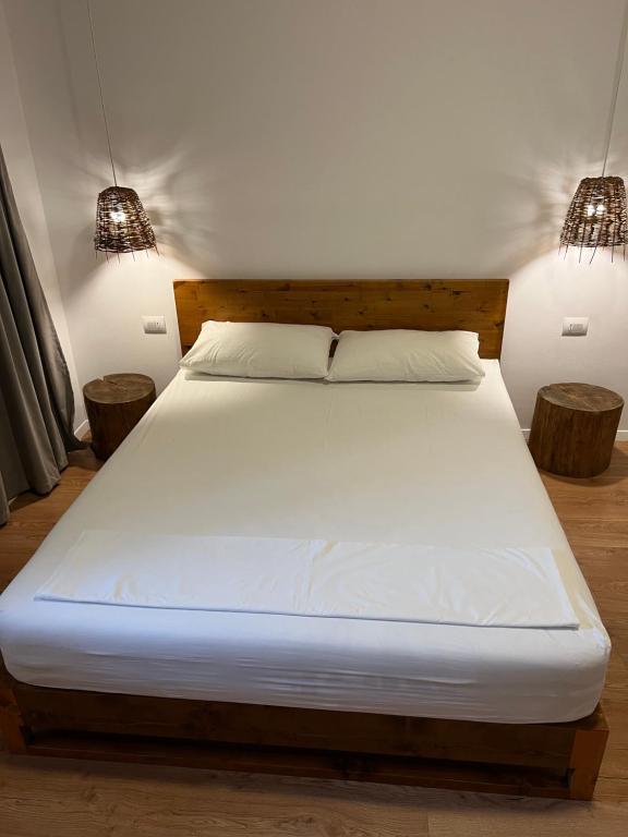 a bedroom with a bed with two lamps on it at Kanes Bohemian Boutique Hotel in Sarandë