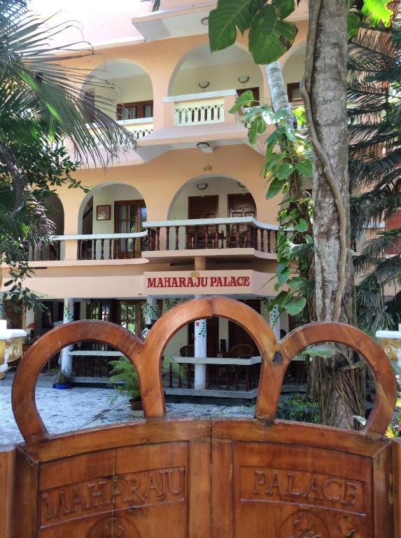 a wooden gate in front of a building at Maharaju Palace in Kovalam