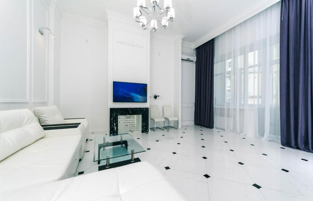 a white living room with a white couch and a fireplace at VIP near Premier Palace & Arena city in Kyiv