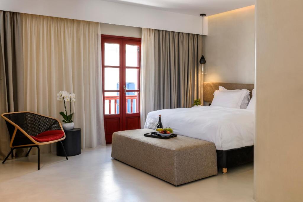una camera d'albergo con letto e sedia di Mykonos Gem a Mykonos Città