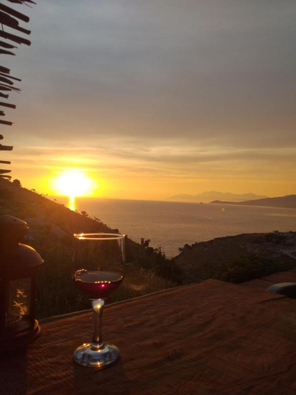 a glass of wine sitting on a table with the sunset at Grand Seaview Apartments in Ksamil