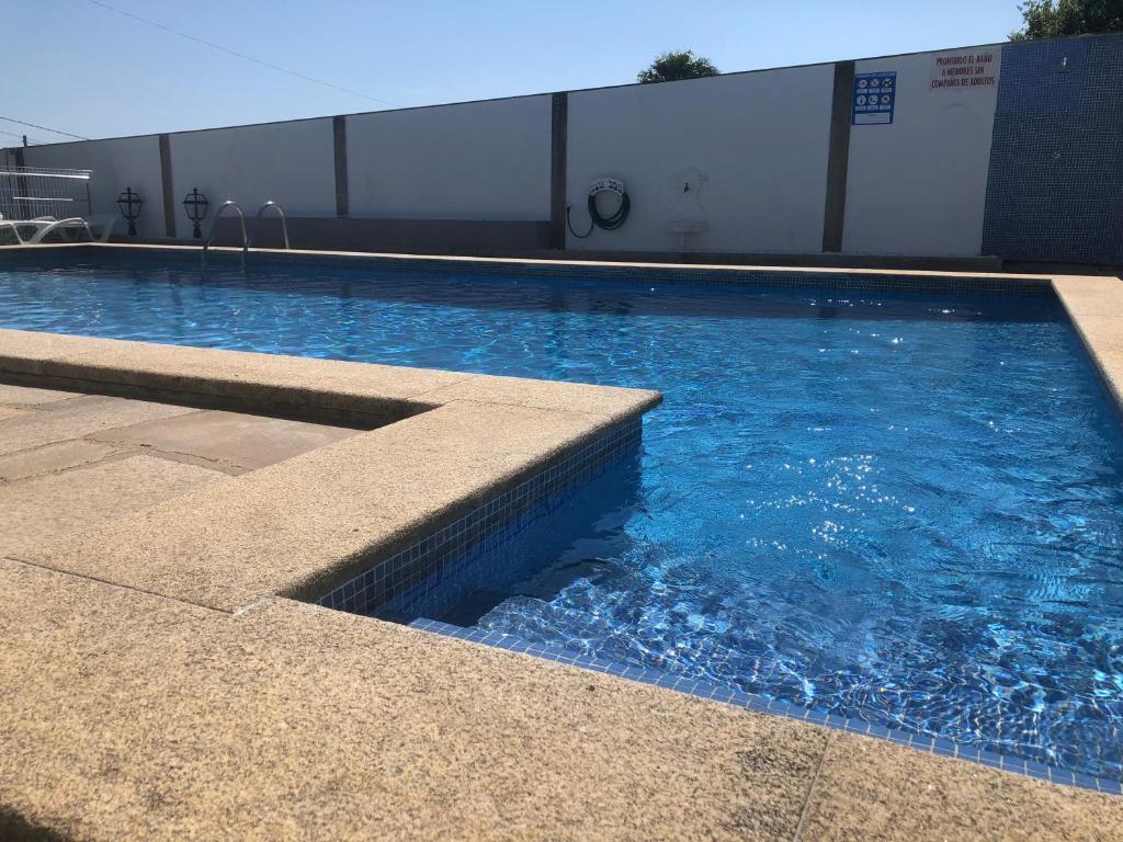 a swimming pool with blue water in a building at Apartamentos Océano in Samieira