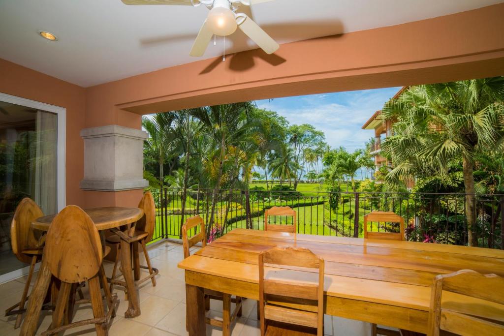 een eetkamer met een houten tafel en een groot raam bij Los Suenos Resort Bay Residence 8C in Herradura