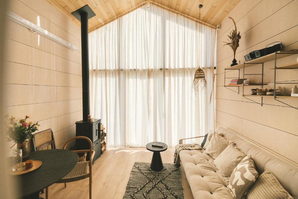 a living room with a couch and a large window at Fejny Dom - Jezioro Dadaj in Kromerowo